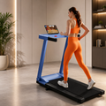 Woman running on a blue foldable treadmill while watching a video on a laptop.