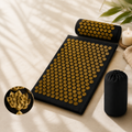 Black acupressure mat and pillow set with gold spikes, includes storage bag.