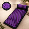 Purple acupressure mat and pillow set with lotus-shaped spikes for relaxation.
