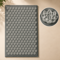 Gray acupressure mat with a flower-shaped spike pattern and a close-up of one spike.
