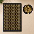 Acupressure mat with hundreds of golden lotus-shaped acupressure points on a black fabric base.