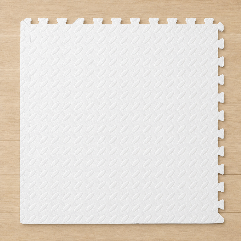 White interlocking foam puzzle mat with a diamond pattern texture, on a light wood floor.