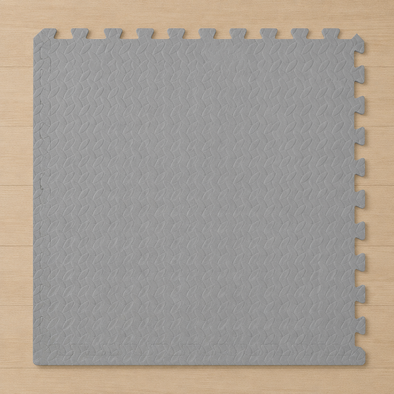 A single gray interlocking foam floor mat with a textured surface on a light wood floor.
