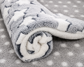 Rolled-up plush dog mat with a gray and white star pattern on a dotted background.