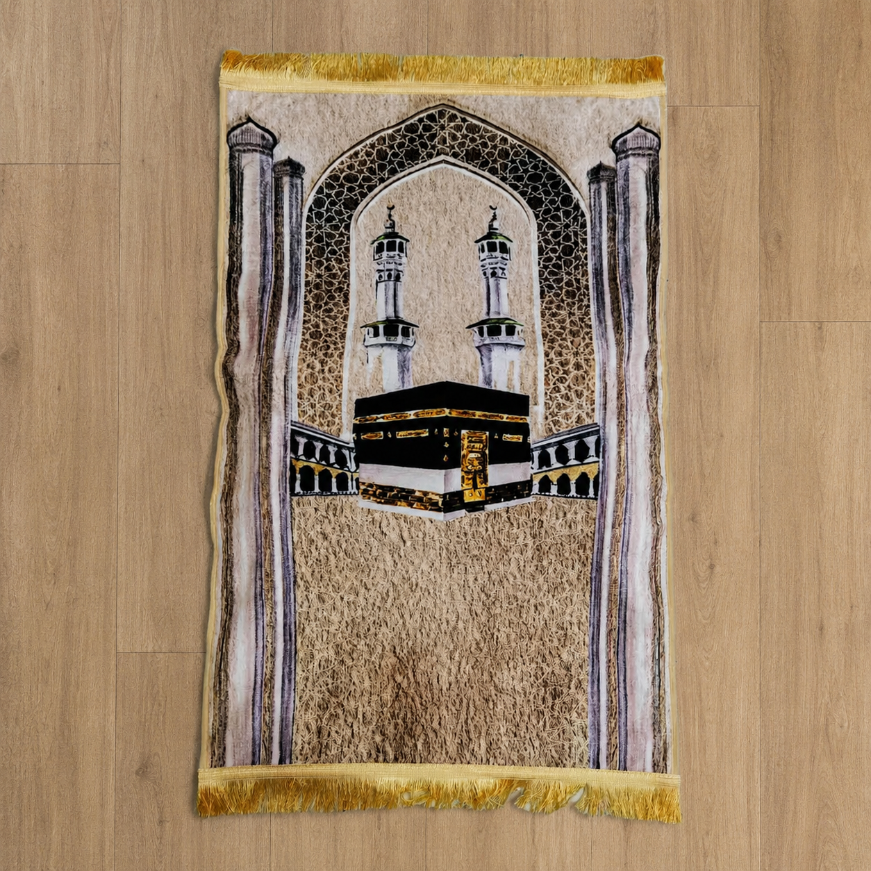 Islamic prayer mat featuring the Kaaba and mosque minarets, with decorative arch and fringe.