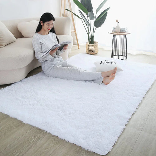 Fluffy white shag rug in a cozy living room setting with a woman reading on it.