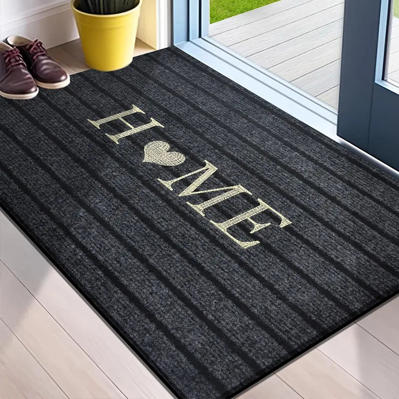 Gray striped welcome mat with "HOME" and a heart design, placed at a doorway.