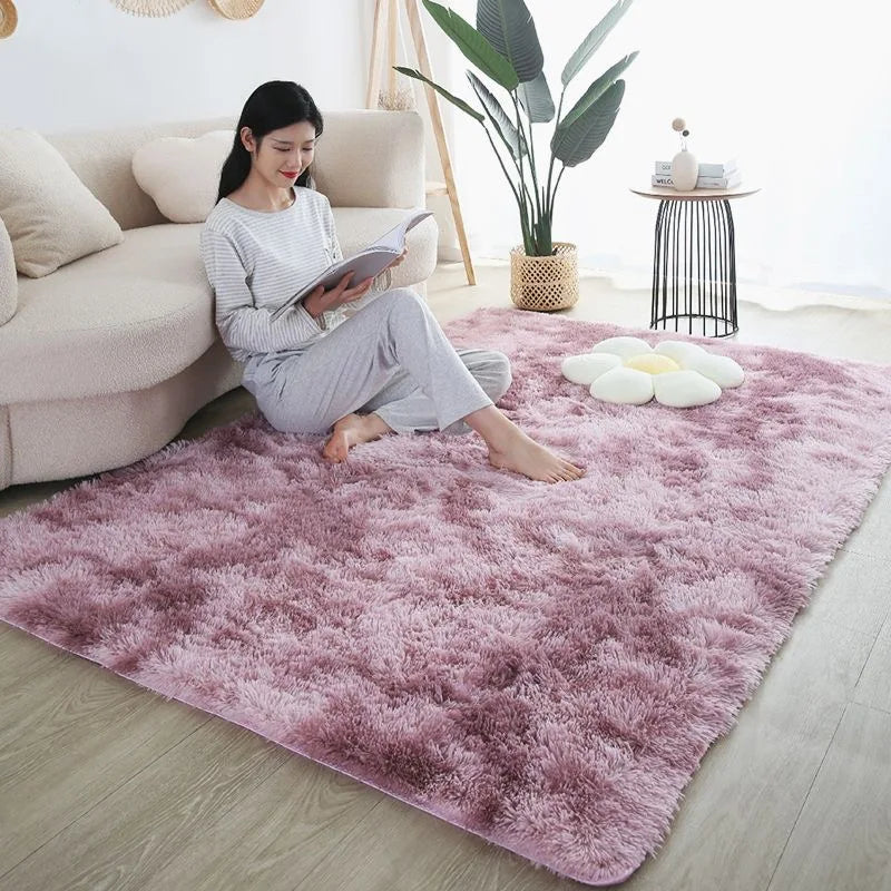 Plush pink ombre rug in a living room setting with a woman reading on it.