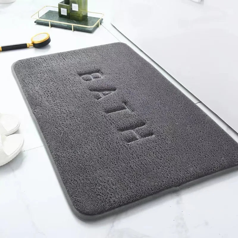 Soft grey bath mat with "BATH" embossed on the surface.