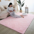Soft pink fluffy rug for children's room, with a woman reading on a sofa.