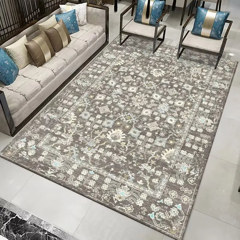 Tapis style persan gris avec un motif floral complexe et des accents bleus clairs, présenté dans un salon moderne.