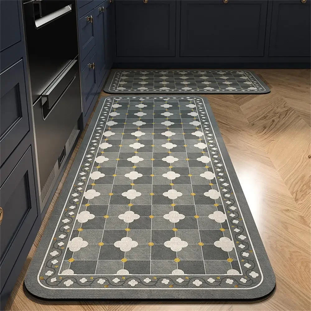 Grey and white patterned kitchen mats with a floral tile design on a wooden floor.