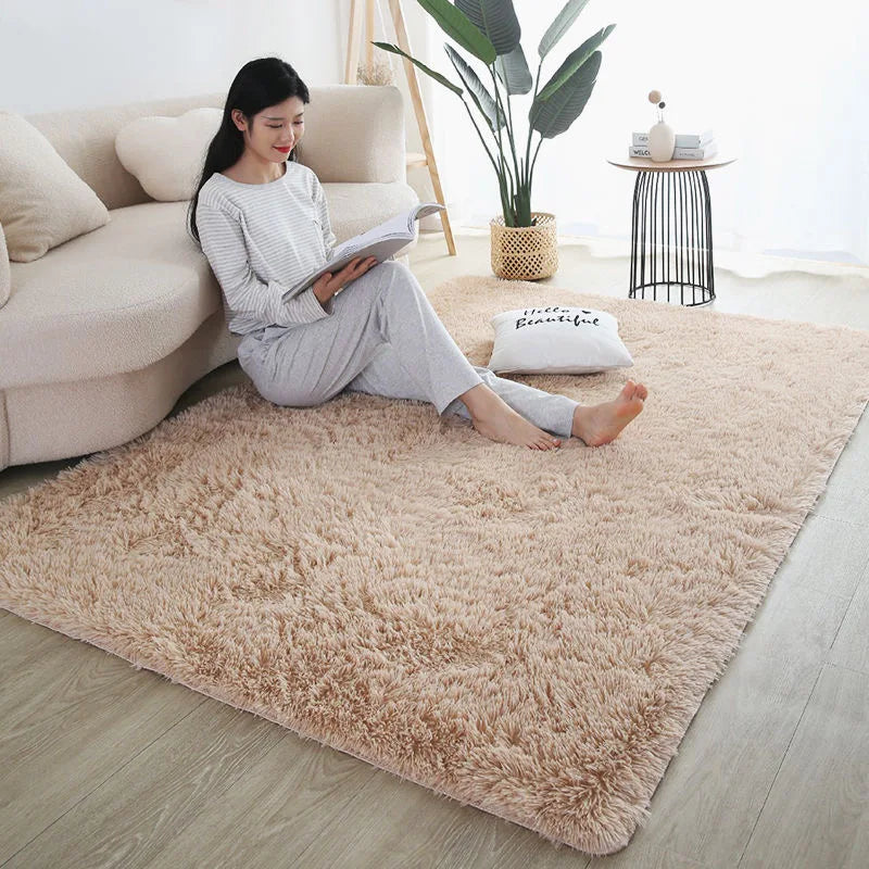 Soft beige plush rug in a bedroom with a young woman reading on the floor.