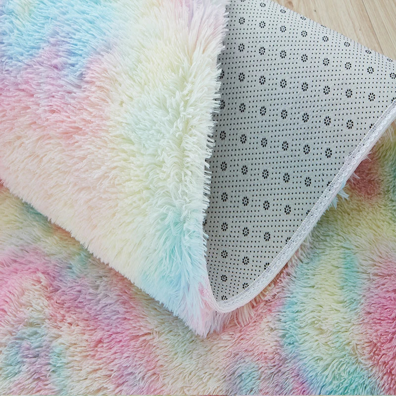 Soft, fluffy tie-dye rug with rainbow pastel colors, perfect for a child's bedroom.