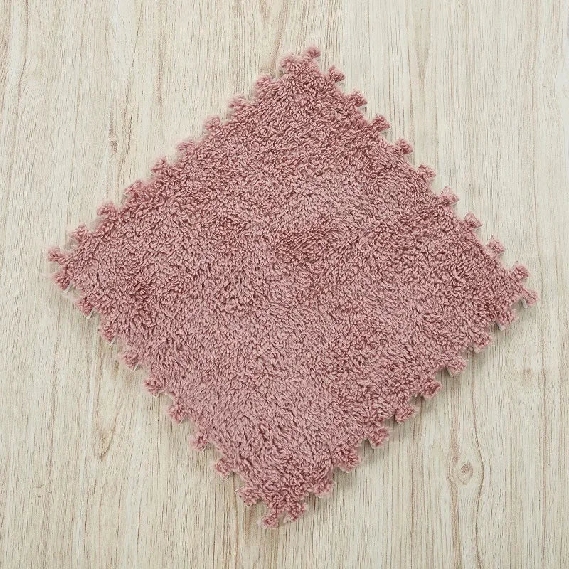 Pink plush interlocking puzzle mat with soft texture and interlocking edges.