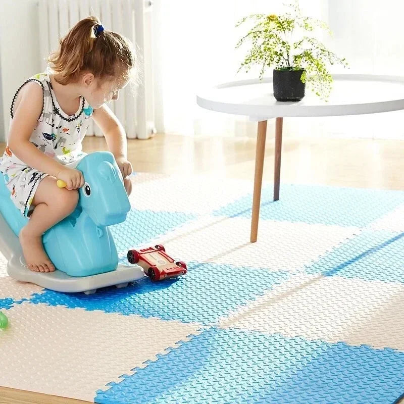 Blue and white interlocking foam puzzle mat with a child playing on a rocking toy.