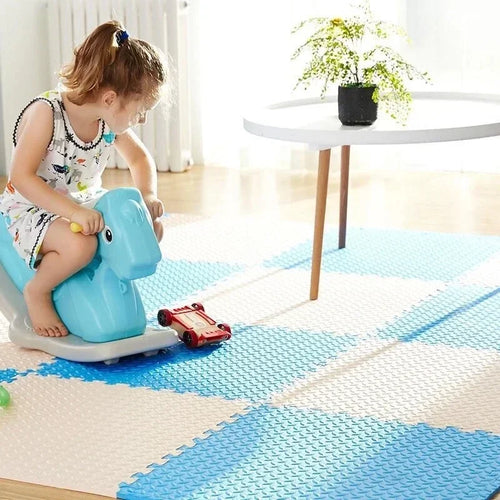 Blue and white interlocking foam puzzle mat with a child playing on a rocking toy.