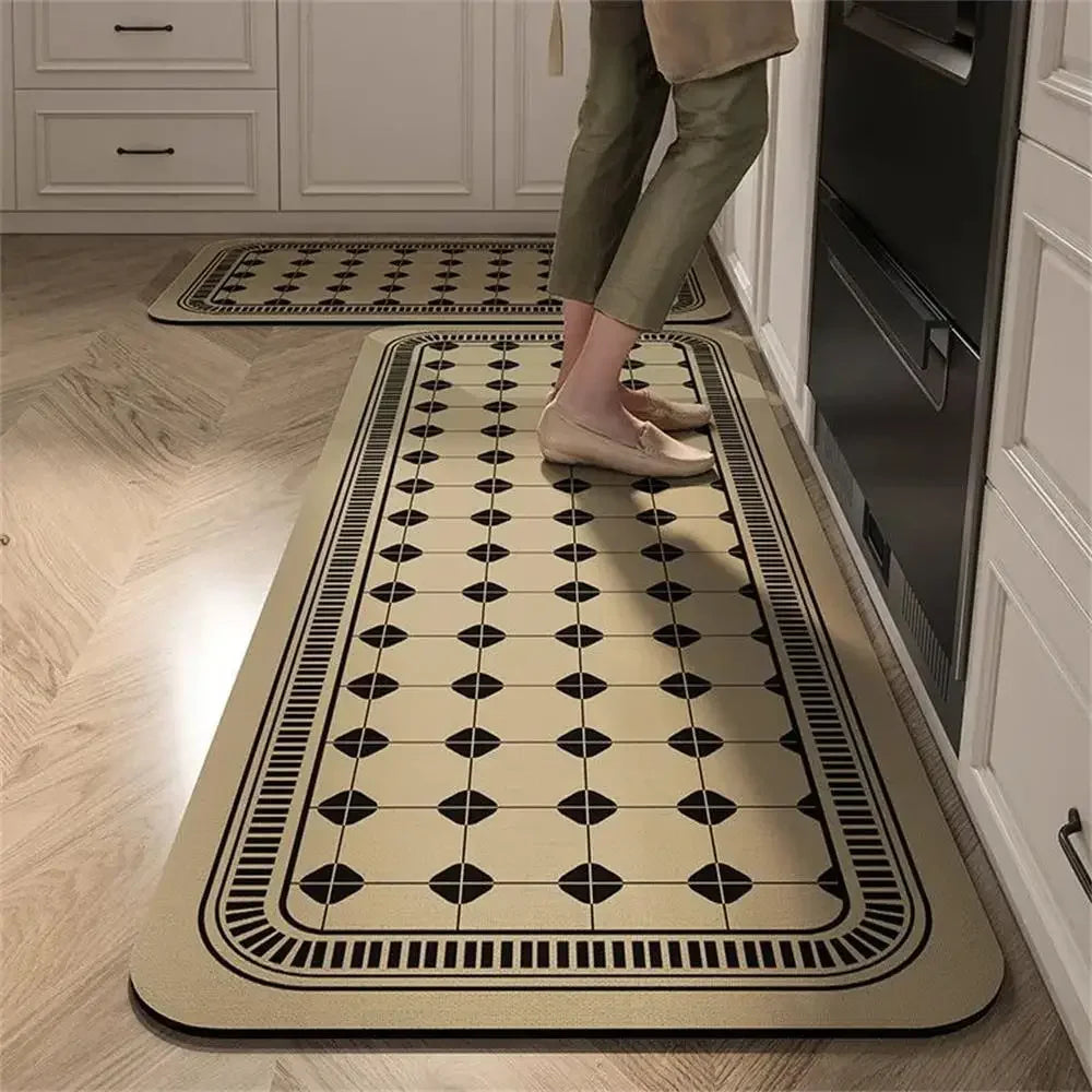 Cream kitchen runner mat with a black geometric tile pattern, placed on a light wood floor.