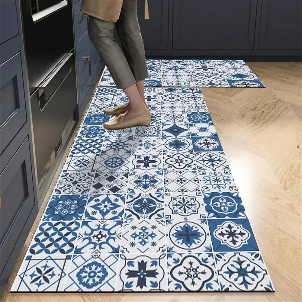 Blue and white patterned kitchen runner mat with a tile design, laid on a wooden floor.
