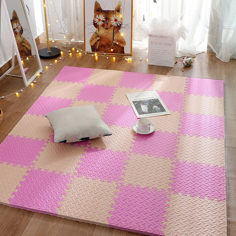 Pink and beige interlocking foam floor tiles arranged in a checkerboard pattern.