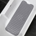 Gray non-slip bath mat with suction cups inside a white bathtub.