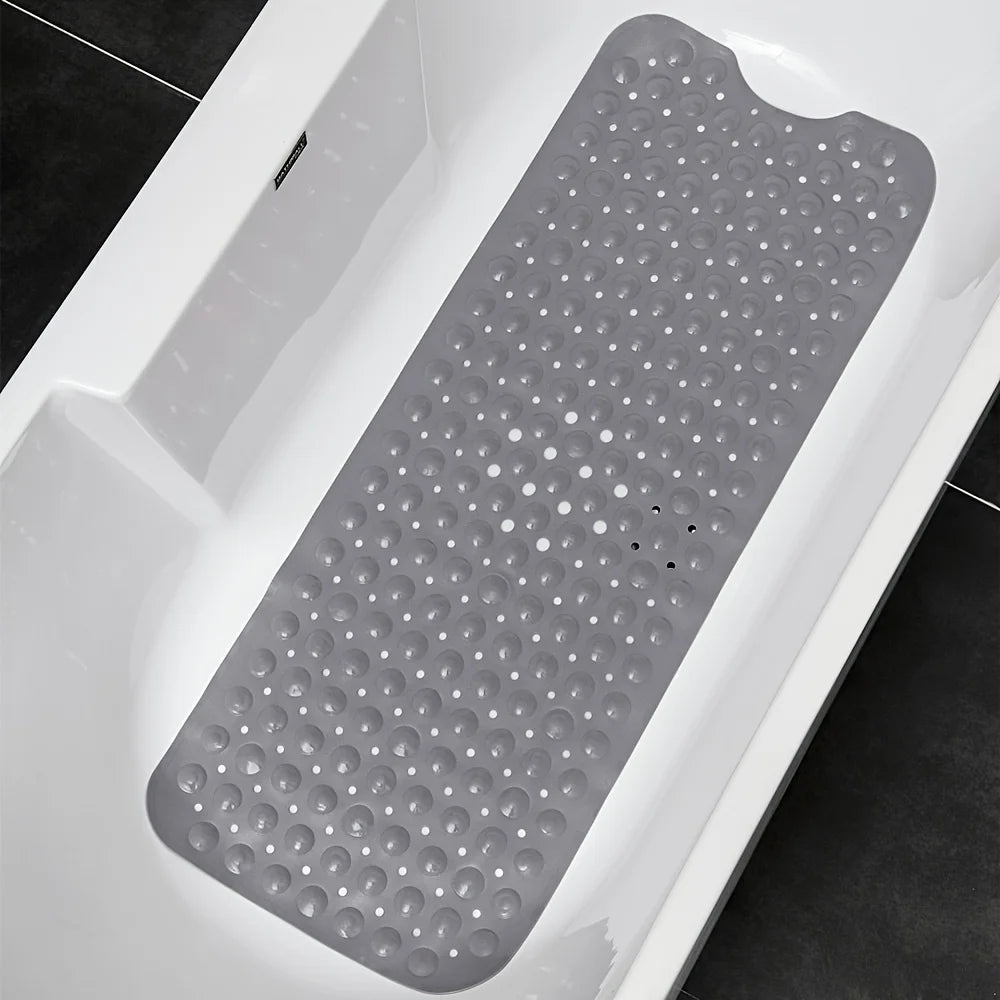 Gray non-slip bath mat with suction cups inside a white bathtub.