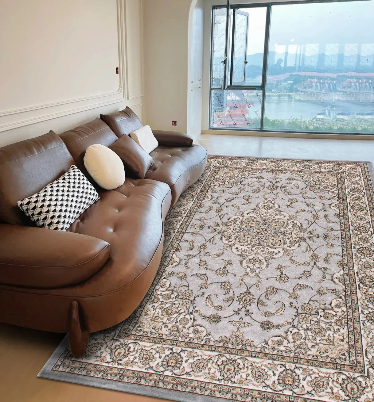 A light grey, ornate Persian style area rug with intricate floral patterns on a living room floor.
