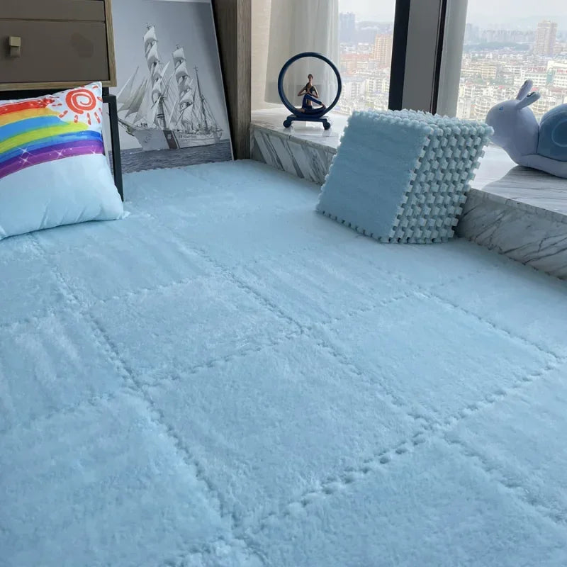 Soft blue interlocking floor mats, creating a plush play area with a rainbow pillow.