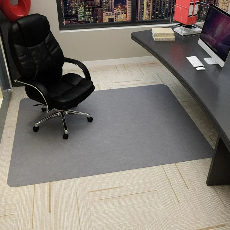 Gray office chair mat on carpet under a desk with a computer.