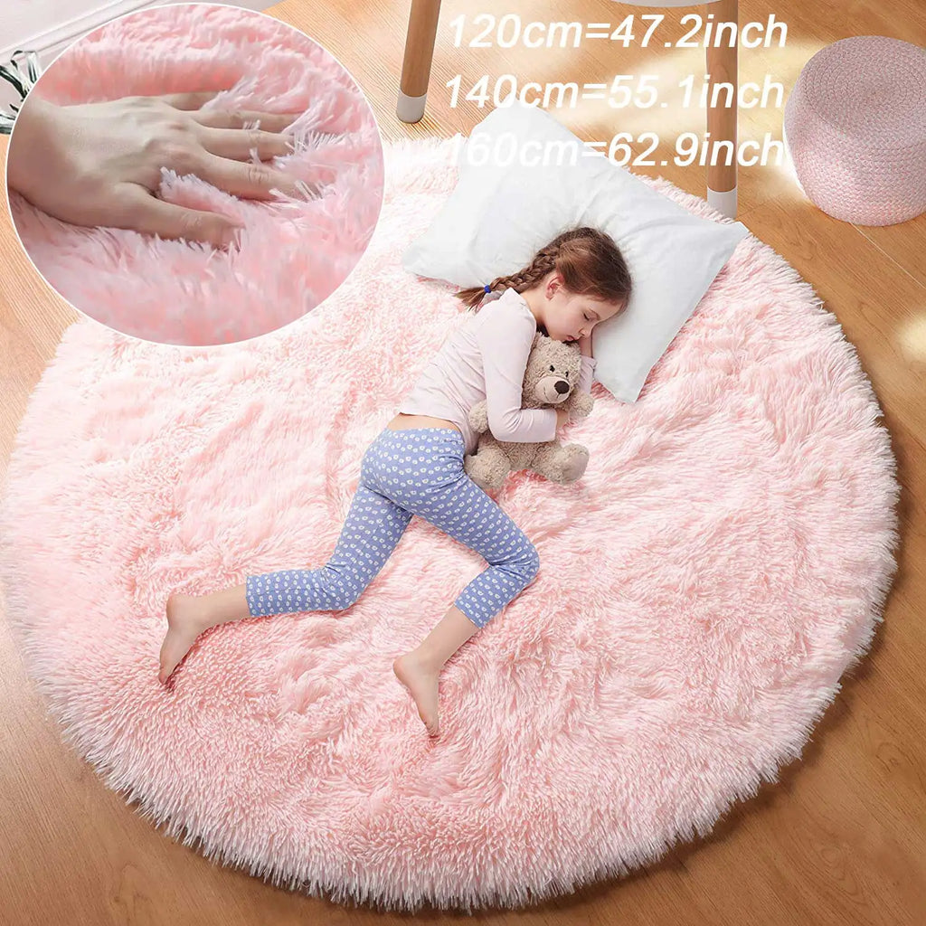 Soft pink round kids' fluffy rug with a sleeping child and teddy bear.