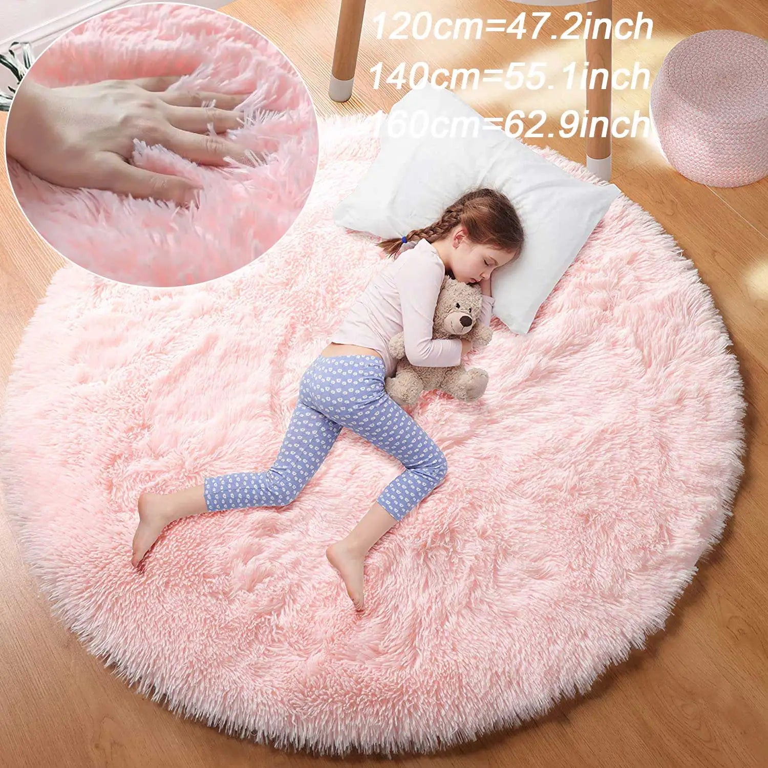 Soft pink round kids' fluffy rug with a sleeping child and teddy bear.
