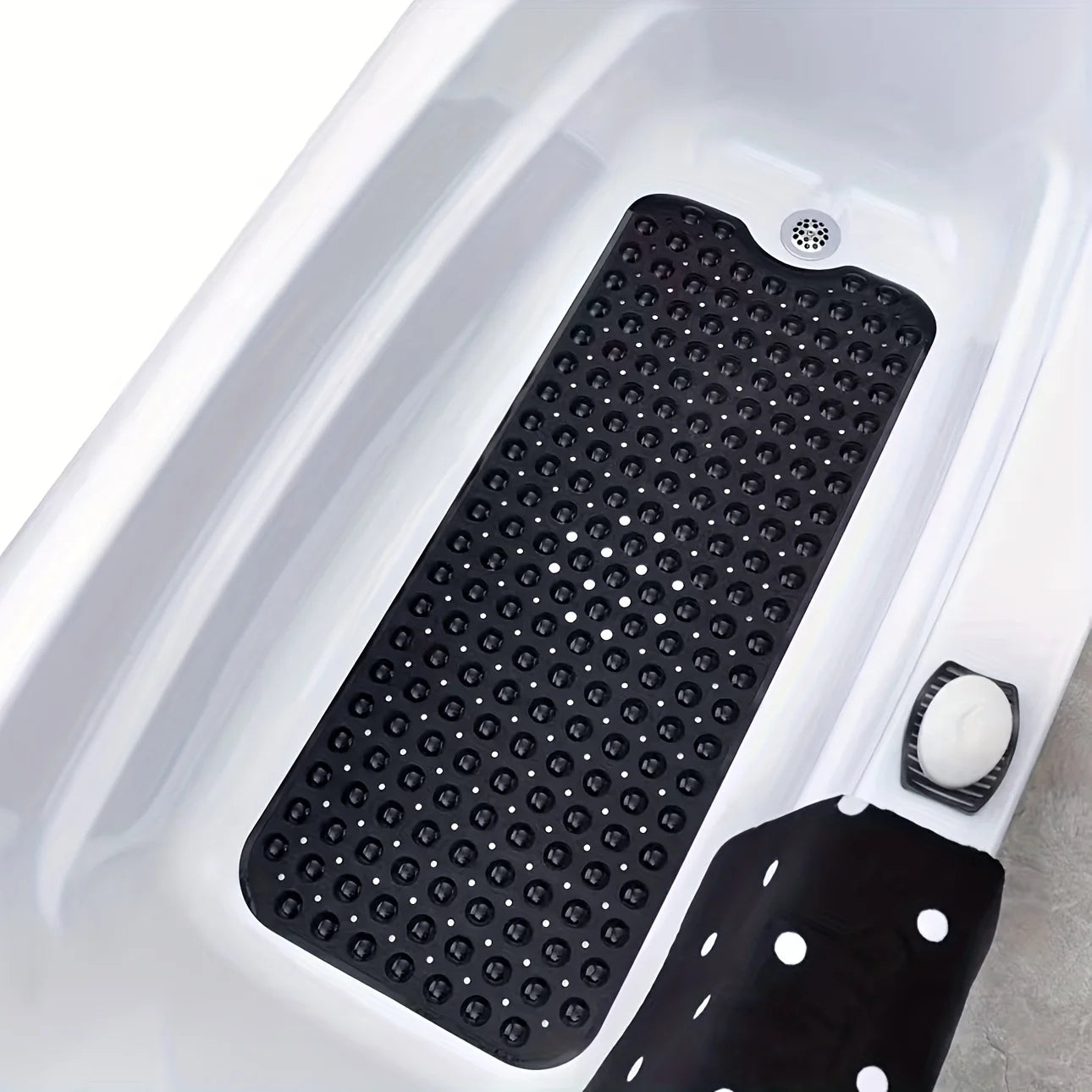 Black textured non-slip bath mat with suction cups inside a white bathtub.