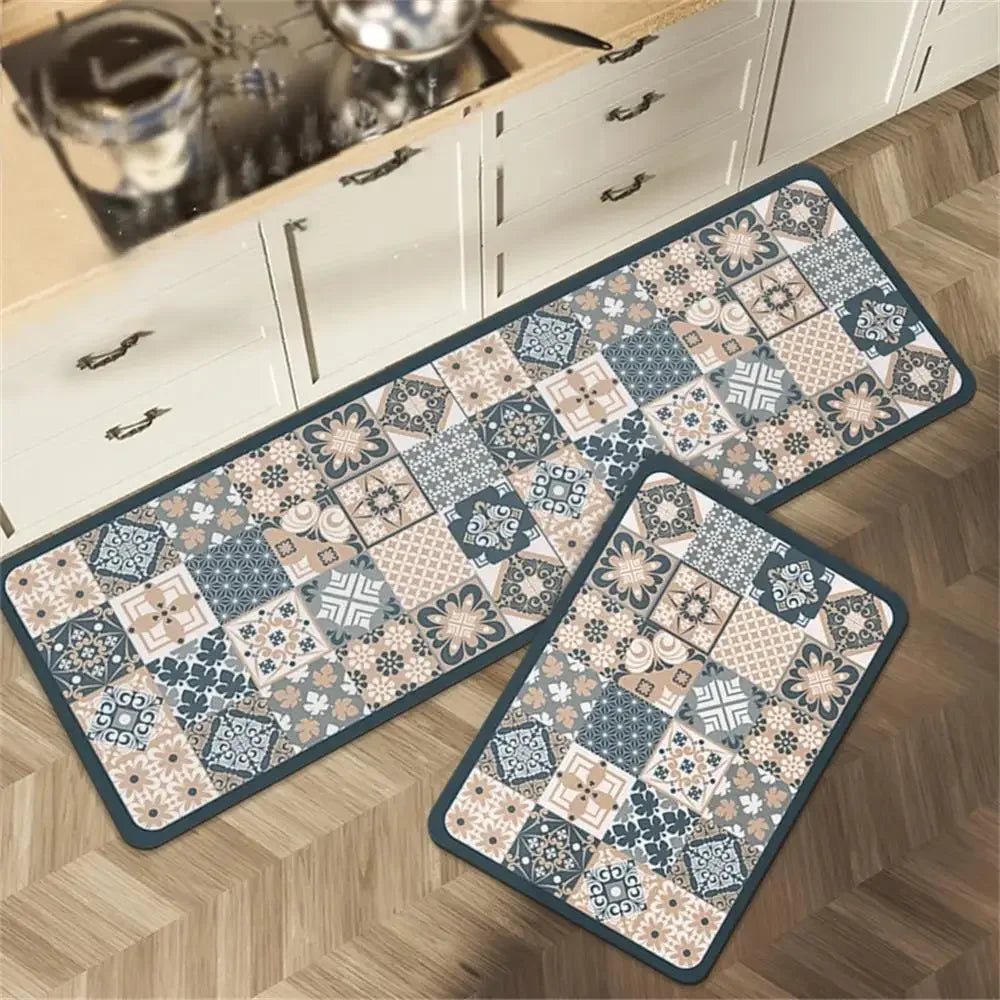 Tapis de cuisine décorés de motifs géométriques et floraux dans des tons bleus, beiges et gris, disposés sur un parquet.